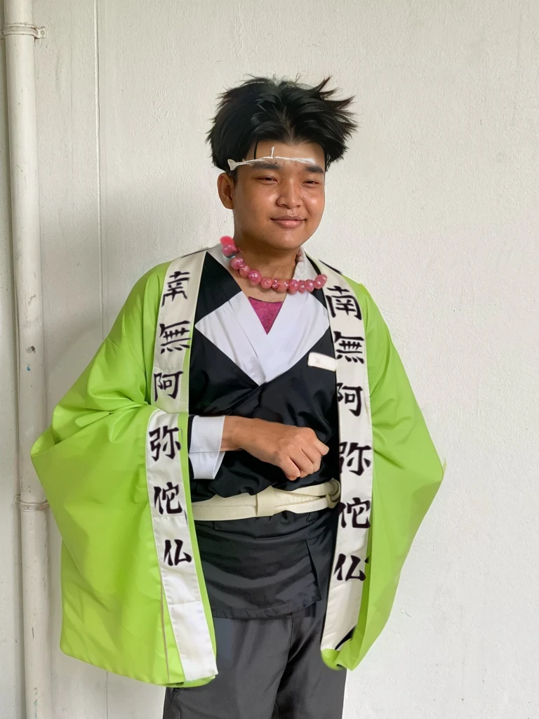 Gyomei has short, spiky black hair.
His hair is neatly cut, with the spikes giving it a rugged yet orderly appearance.
Forehead Scar:
Gyomei has a prominent scar running horizontally across his forehead.
The scar is a thin, straight line that goes from one side of his forehead to the other, adding to his rugged and battle-hardened look.
