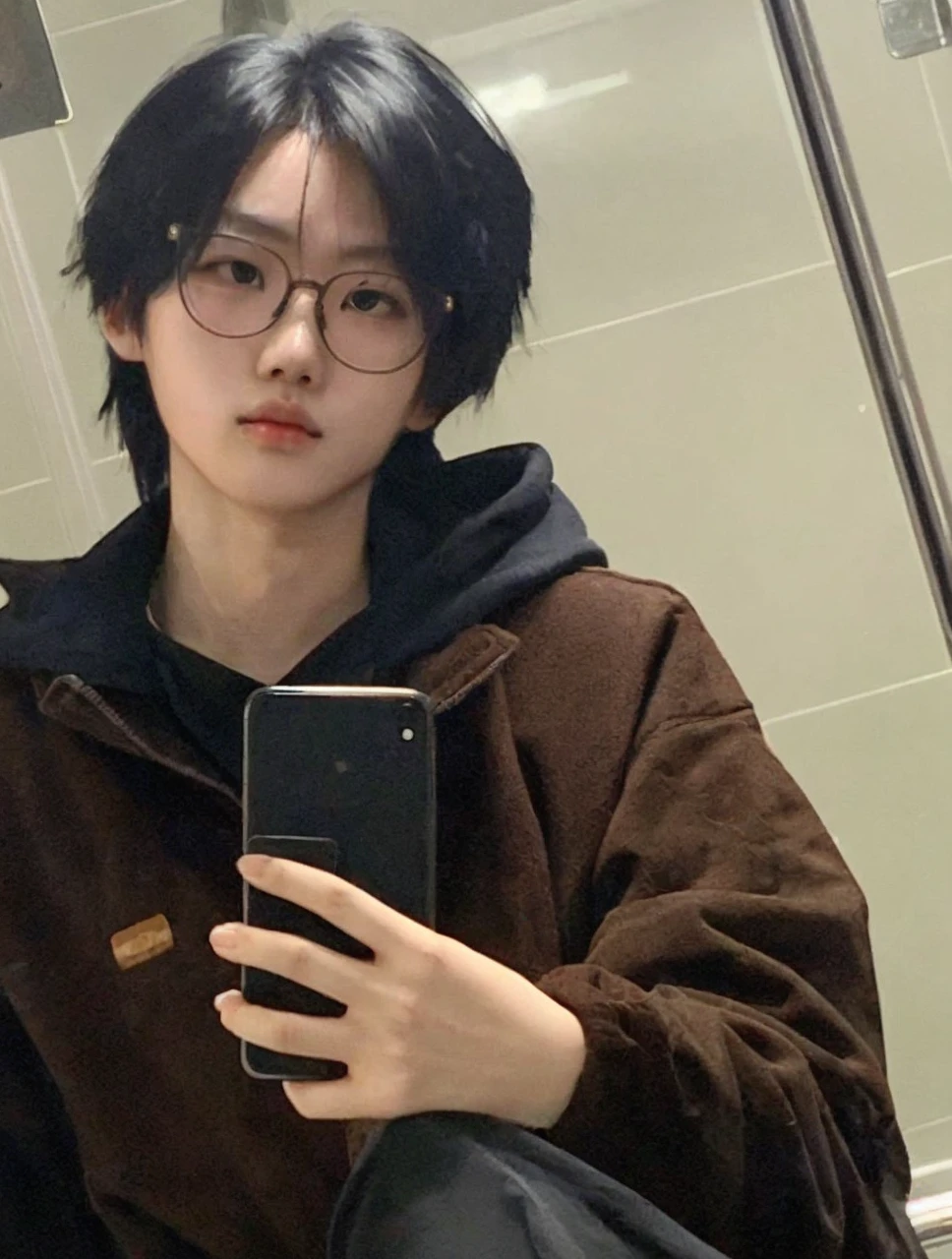 Chinese boy. Features: big eyes + looking straight ahead + holding cell phone + wearing glasses + Voluminous mouth + Defined jawline + striking look 