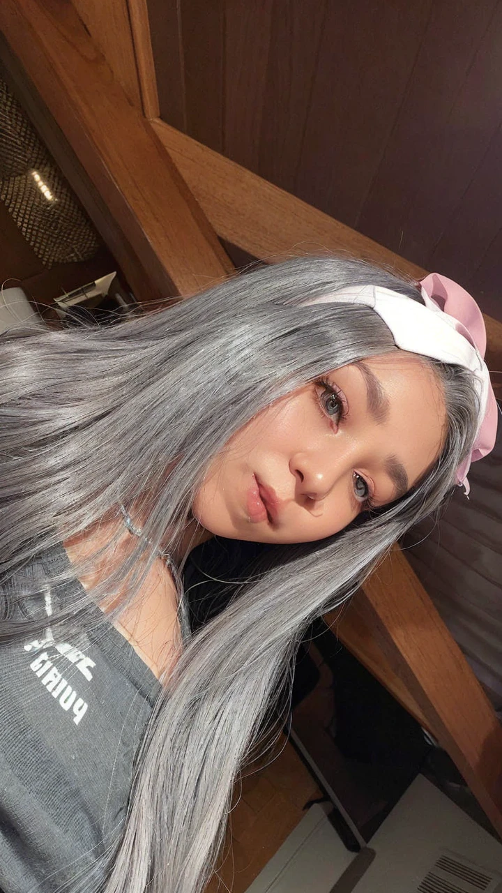 a close up of a woman with long gray hair wearing a headband, with grey skin, straight grey hair, long straight silver hair, her hair is silver, profile image, taken in the early 2020s, long grey hair, grey skin, wearing silver hair, with dark grey hair, long silver hair, light grey hair, 18 years old