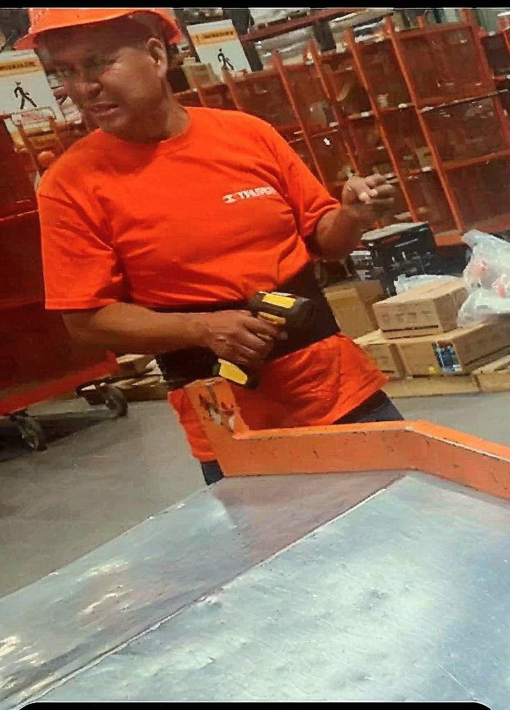 nude Hawaiian man squatting, athletic masculine male sitting on small wooden stool In warehouse wearing a construction helmet. rear view.
