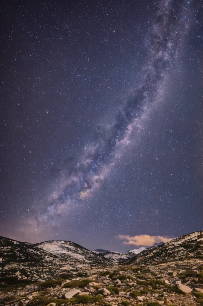 Night full of stars, mountains can be seen in the background 