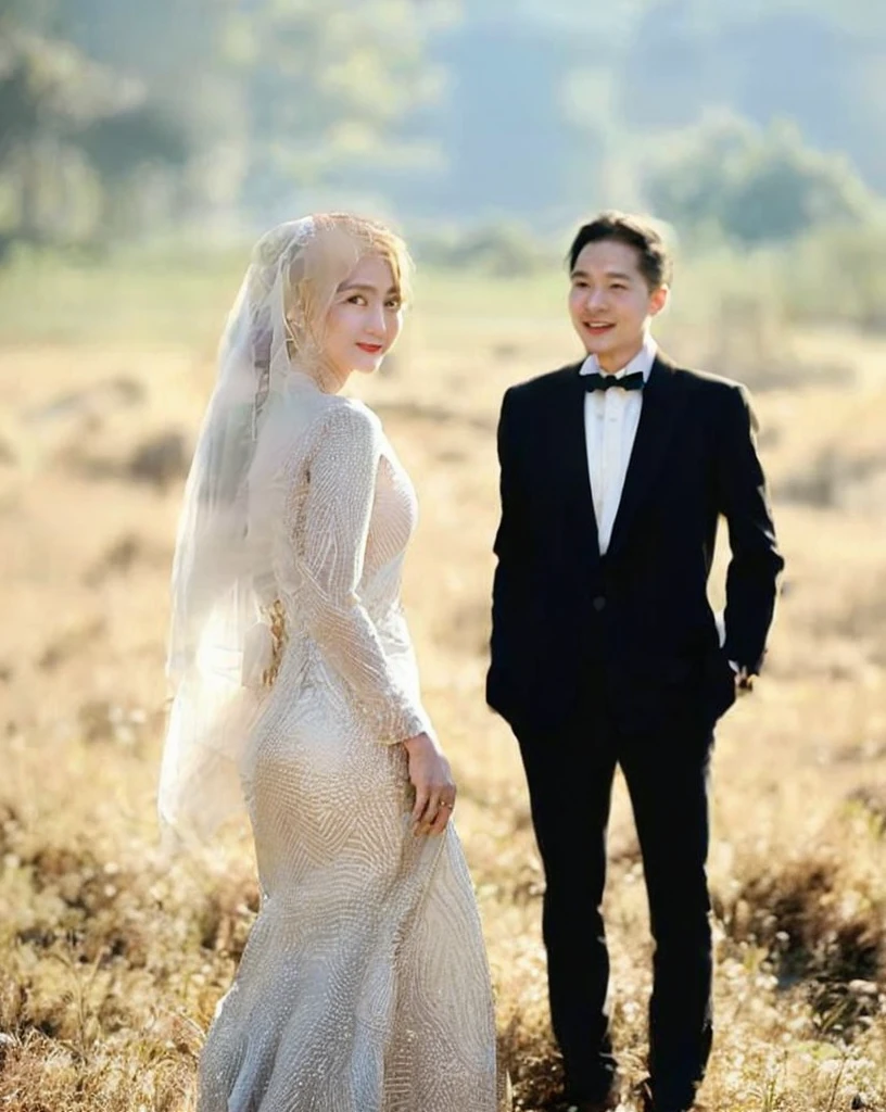 a man and woman in a tuxedo standing in a field, bride and groom, lovely couple, wedding photo, happy couple, luxurious wedding, couple, wedding, couple pose, during sunset, instagram post, by Basuki Abdullah, in the background, wedding dress, formal attire, wearing a wedding dress, white hijab, groom, background is heavenly