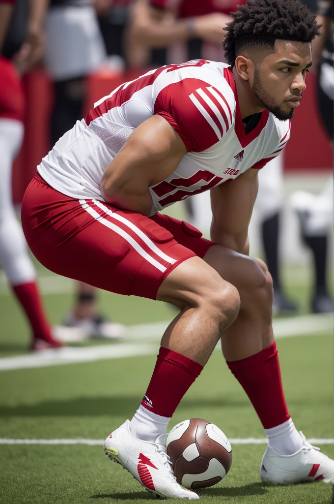 A football player wearing a shirt with red vertical stripes, slightly dark red shorts and white socks that go up to the knees
