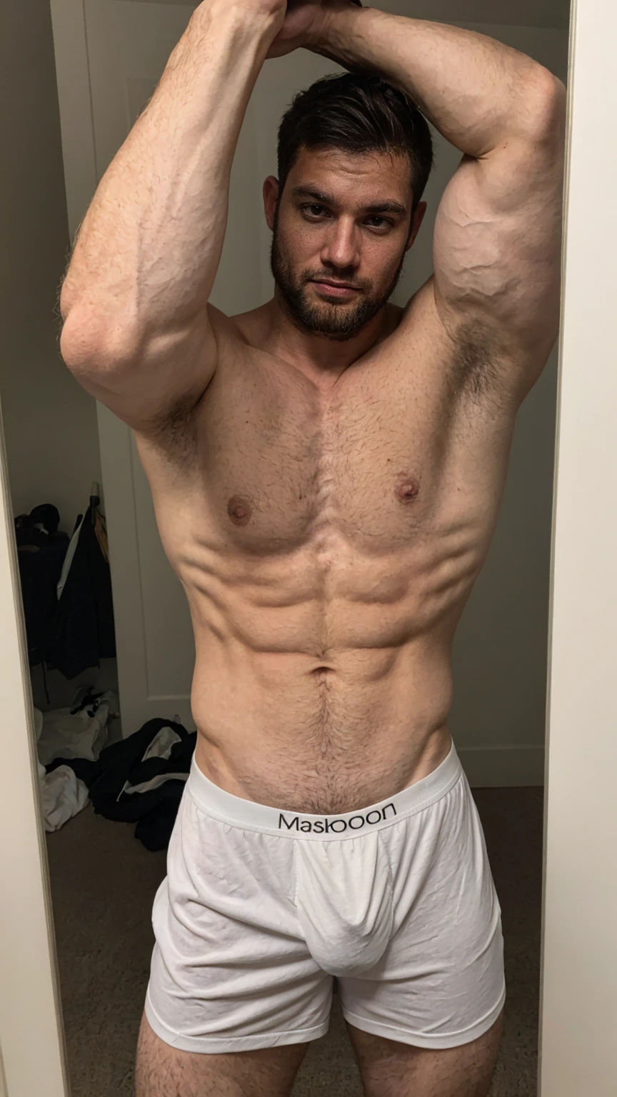 Real image of muscular and hairy man, short black hair, short beard, shirtless, wearing a white boxer. taking a selfie in a mirror.