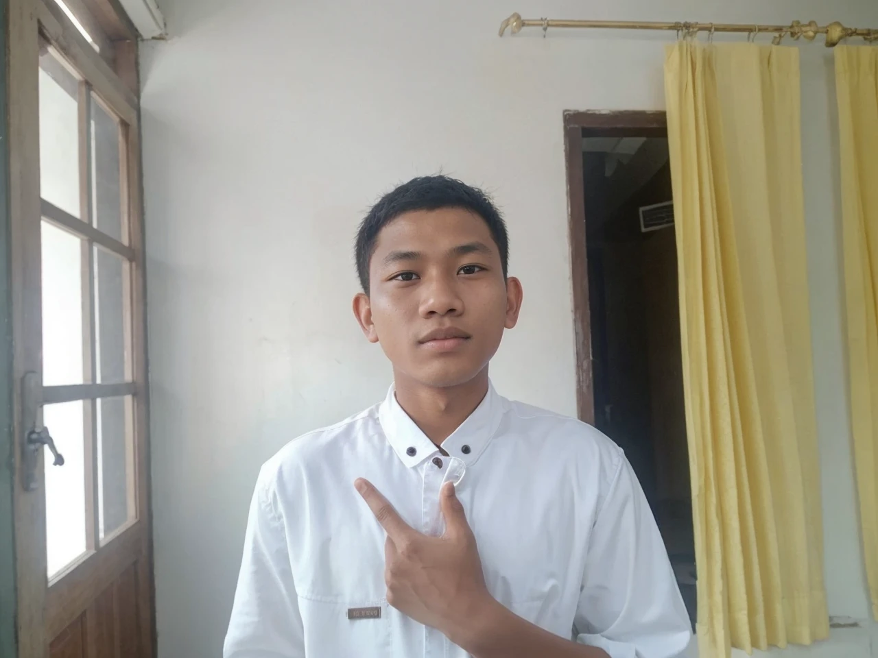 Indonesian age boys. Age around 22 years. There is only one person in the photo. wearing a white jacket. The whole body is depicted facing forward. The background is a river in the forest.