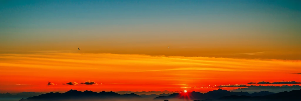 Orange afternoon sky, mountain, birds flying 