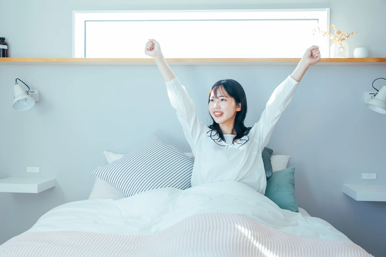 woman in white shirt laying in bed with arms raised in air, Morning Time, Pause(Raise the hand + Happy), She expressed her joy, in the morning, with Raise the hand, white bed, wearing a simple robe, wake up, During the dawn, early morning, radiant morning light, wearing white pajamas, Morning sunlight, early in the morning, bed, Wearing a nightgown