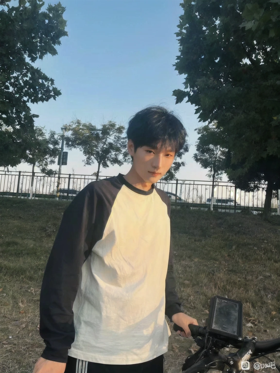 Young man in Arav standing next to his bicycle in the park, xintong chen, Bat Ulzan, Kim Do-young, As the sunset, Cheng Man Kit, yanjun chengt, In sunny weather, Wenjun Lin, cai xukun, short hair, Very very low quality image, Profile picture 1024px, The afternoon light is beautiful
