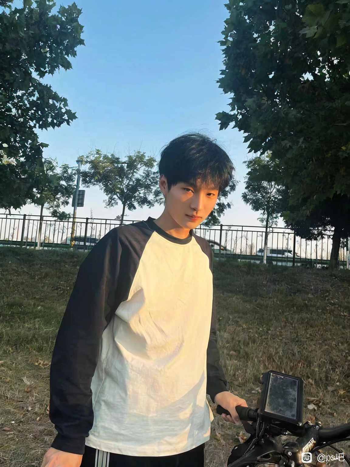 Young man in Arav standing next to his bicycle in the park, xintong chen, Bat Ulzan, Kim Do-young, As the sunset, Cheng Man Kit, yanjun chengt, In sunny weather, Wenjun Lin, cai xukun, short hair, Very very low quality image, Profile picture 1024px, The afternoon light is beautiful