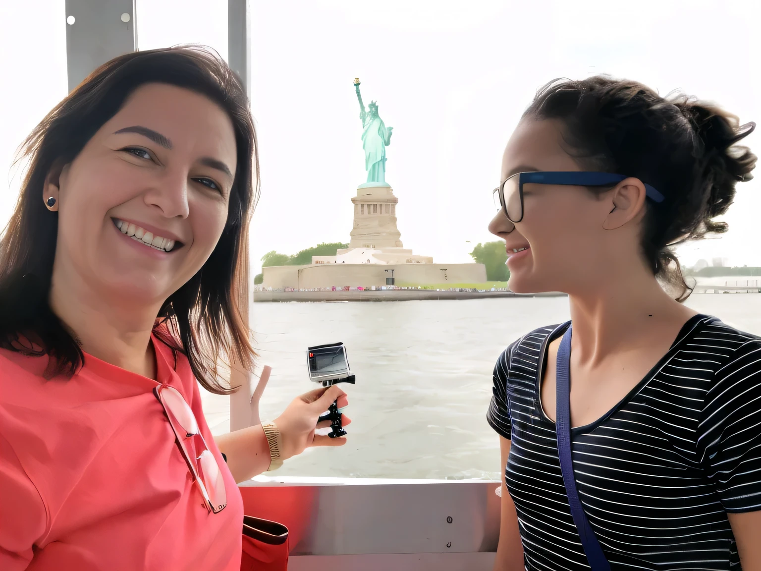 woman holding a cell phone and smiling at the camera, on liberty island, statue of liberty at left, statue of liberty, photo of the statue of liberty, the statue of liberty, in the middle of new york, liberty statue sitdown pose, tourists in background, usa-sep 20, scenic full shot, interior of staten island ferry, very accurate photo