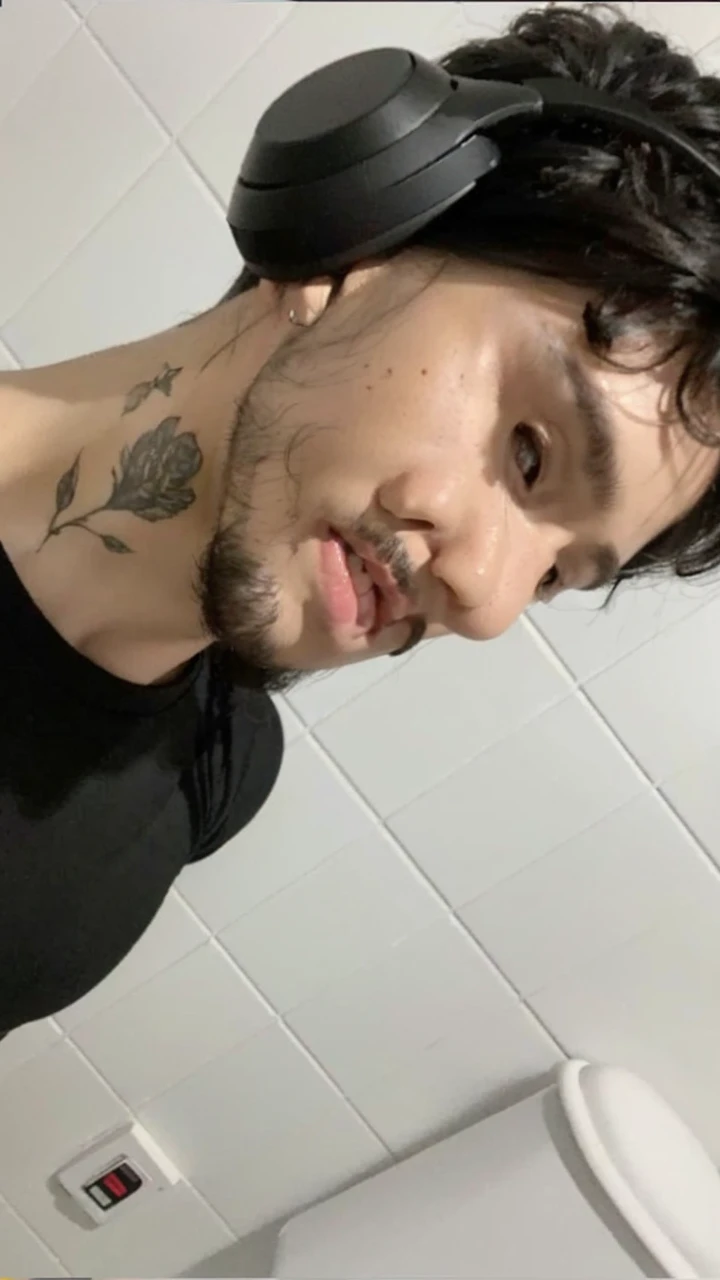 a smiling man with black hair wearing headphones, beautiful detailed eyes, beautiful detailed lips, extremely detailed face, longeyelashes, detailed facial features, closeup portrait, cinematic lighting, warm color tones, photorealistic, (best quality,4k,8k,highres,masterpiece:1.2),ultra-detailed,(realistic,photorealistic,photo-realistic:1.37),HDR,studio lighting,sharp focus,vivid colors,professional portrait
