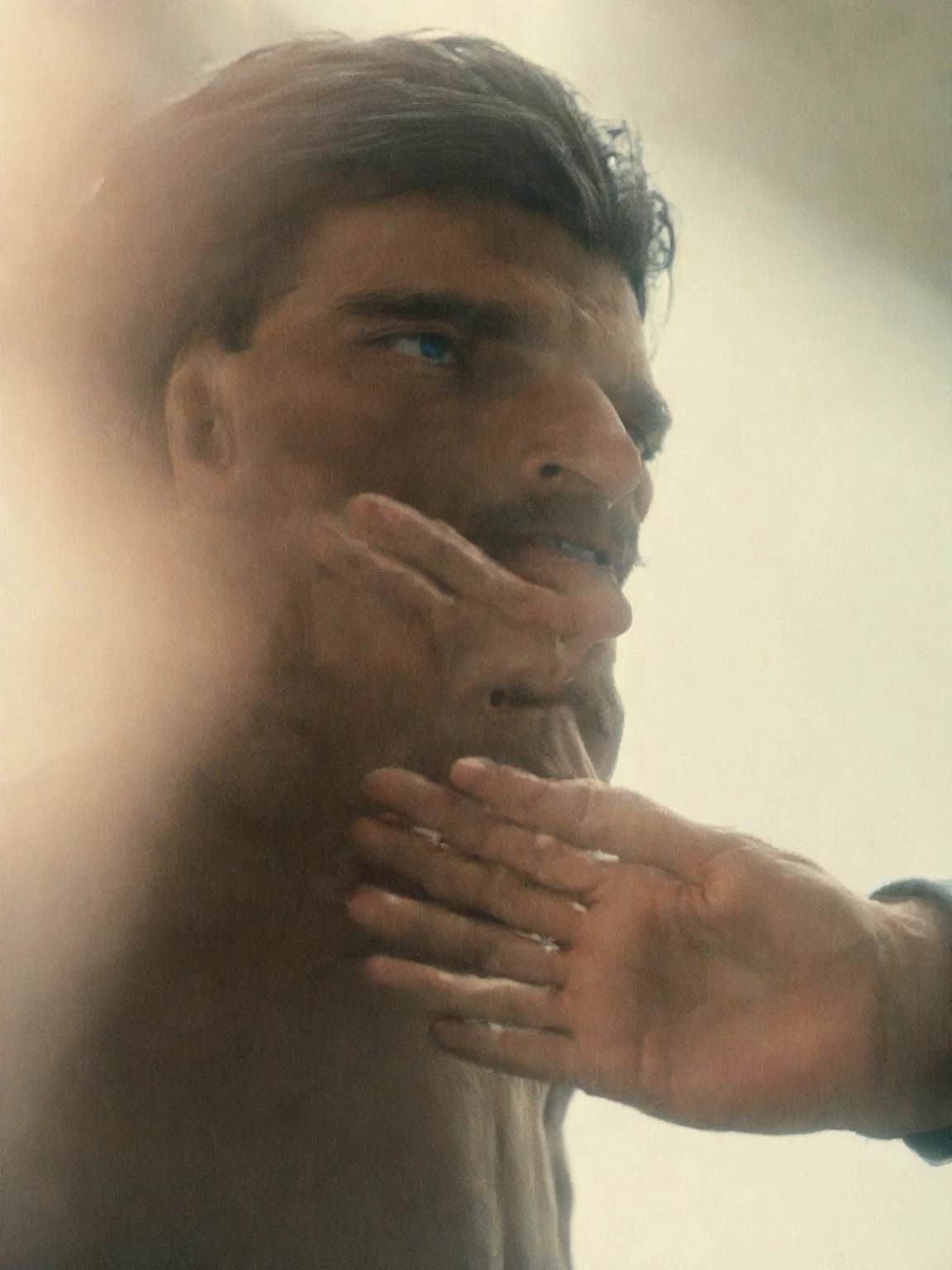 35mm movie scene close up of a man with long black hair and blue eyes putting his hands on a wall 