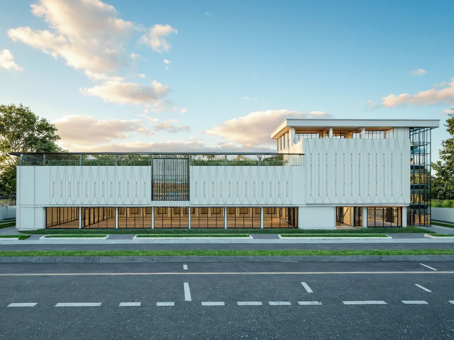 Masterpiece, high quality, best quality, authentic, super detail, outdoors, wedding center style neoclassic, city landscape, white wall, glass windows, gate road, pavement, grass, trees, blue sky, sunset, cloud, (day:1.1), realistic lighting
