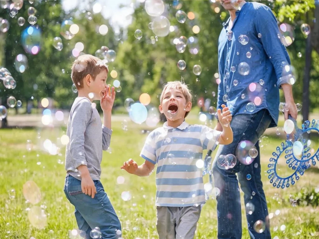 there are two boys and a man playing with bubble in the park, bubble in the air, lots of bubble, soap bubble, bubble, bubble everywhere, Have a great time, bubble of the impossible, foamy bubble, huge bubble, Children playing, Have a great time, shutter, explosive bubble, air bubble, Warm and convivial atmosphere, escaping air bubble