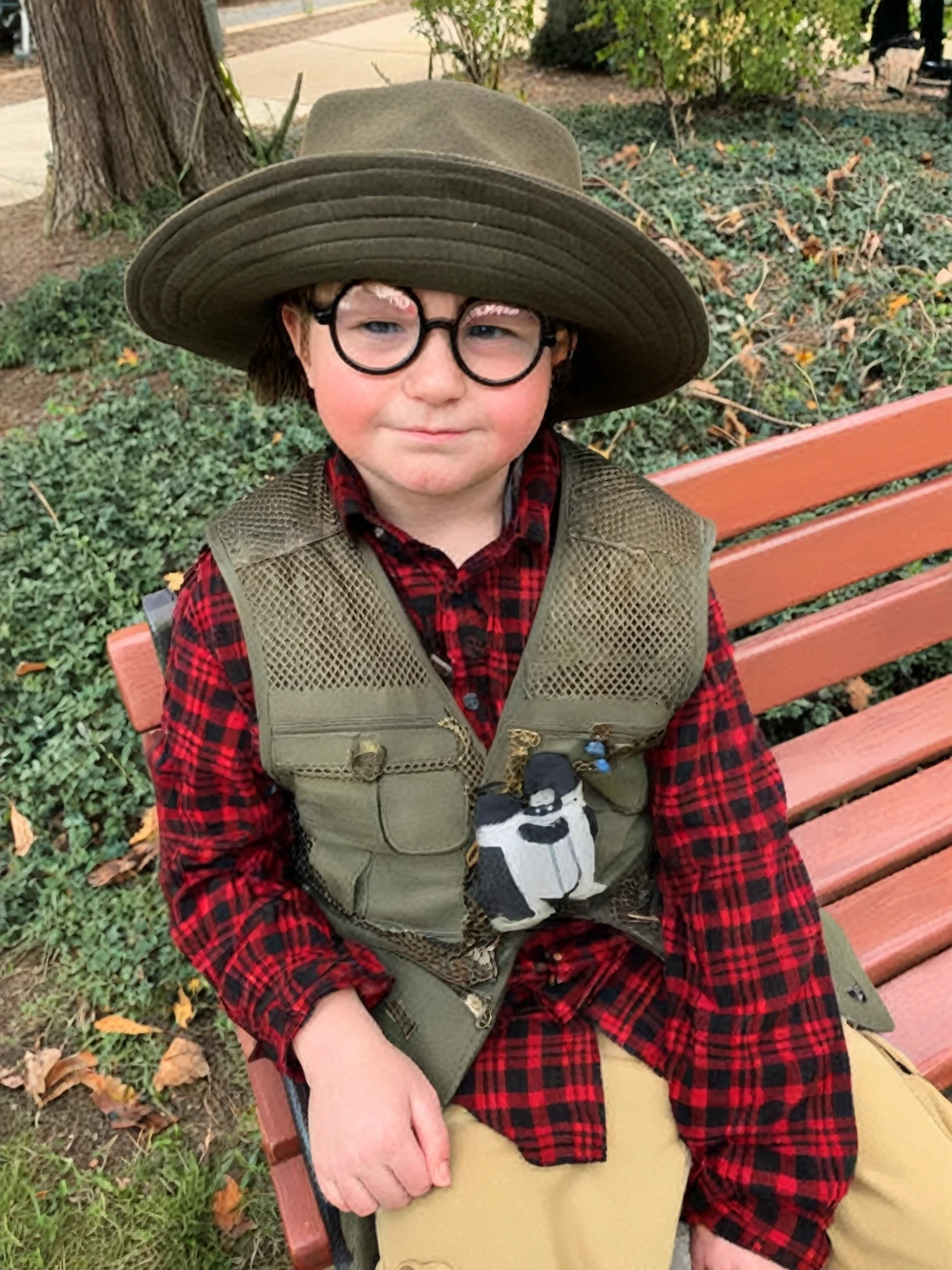 arafed boy wearing a hat and vest sitting on a bench, dressed as a scavenger, inspired by Henry Carr, full costume, inspired by Georges Lemmen, wearing a fisher 🧥, dressed as a western sheriff, by Kristin Nelson, inspired by Theodore Major, by Winona Nelson, woody from toy story, inspired by Willy Finch, as a pixar character