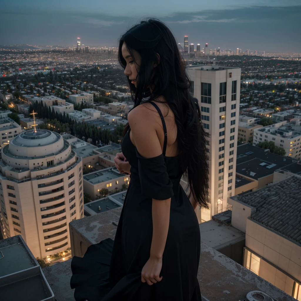 a girl with messy long black hair facing his back wearing a black elegant dress on top of the building overlooking los angeles at night