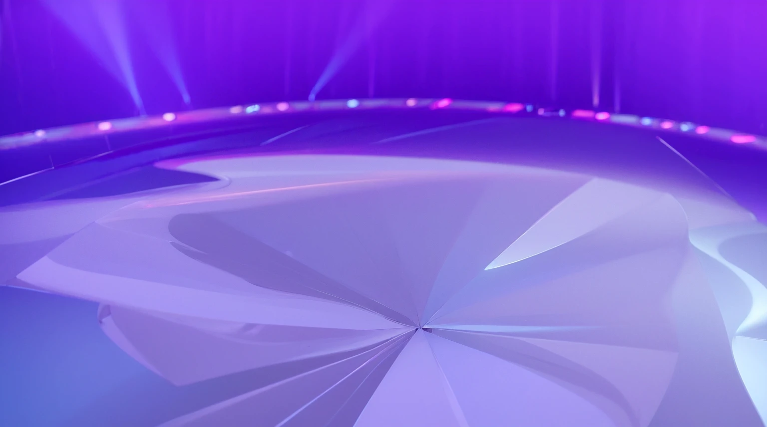 This image showcases a circular stage with a vibrant purple and blue gradient background. The stage floor is designed with radiating segments that create a pattern emanating from a central point. The edges of the stage are illuminated with soft, glowing lights, adding to the overall ethereal and dramatic atmosphere. The combination of colors and lighting effects creates a visually striking and dynamic scene, suitable for performances or events that require a captivating and immersive setting