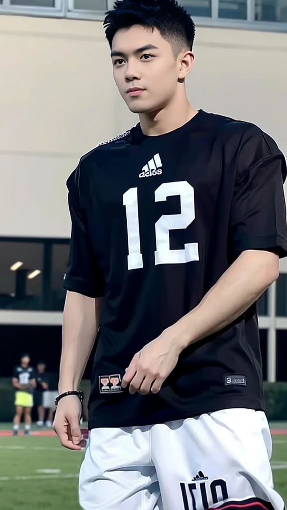 Handsome young man. Handsome young man, 20 years old.,Looking at the camera,Wearing a black Adidas t-shirt, standing on the football field.