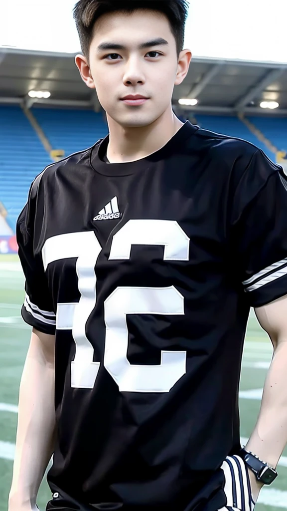 Handsome young man. Handsome young man, 20 years old.，Looking at the camera，Wearing a black Adidas t-shirt, standing on the football field.
