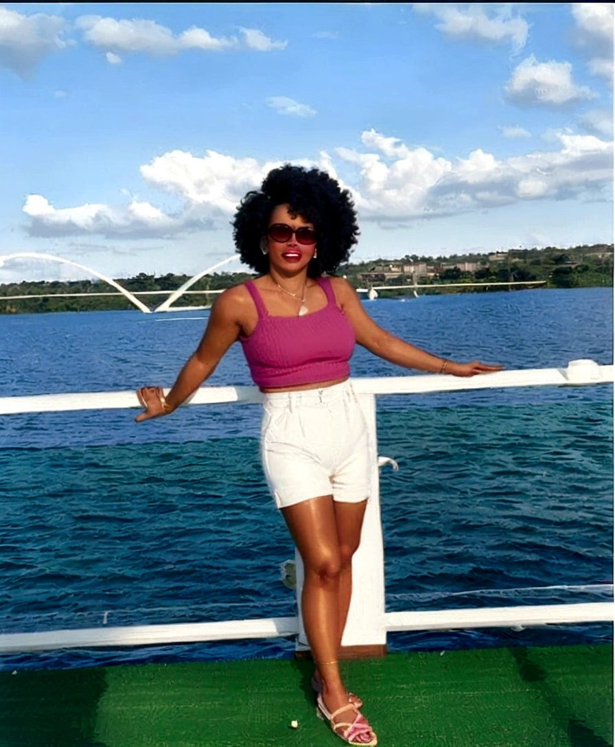 araffe woman in a pink top and white skirt on a boat, 30-year-old woman from cuba, standing on the deck of a ship, wearing a sweater and shorts, with afro, on a boat, standing on the deck of the ship, curly afro, on a boat on a lake, wearing a tank top and shorts