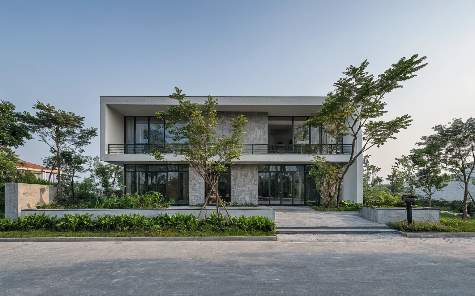 Raw photo, Masterpiece, high quality, best quality, authentic, high realistic, super detail, Realistic green tree exterior, outdoors, Tuonghoagio, house, modern stytle, on the street, wind flower wall, glass windows, GRAY STONE wall, GRAY metal gate, metal railing, house style modern on the street road, pavement, grass, trees, sky, cloud, (daylight:1.1)