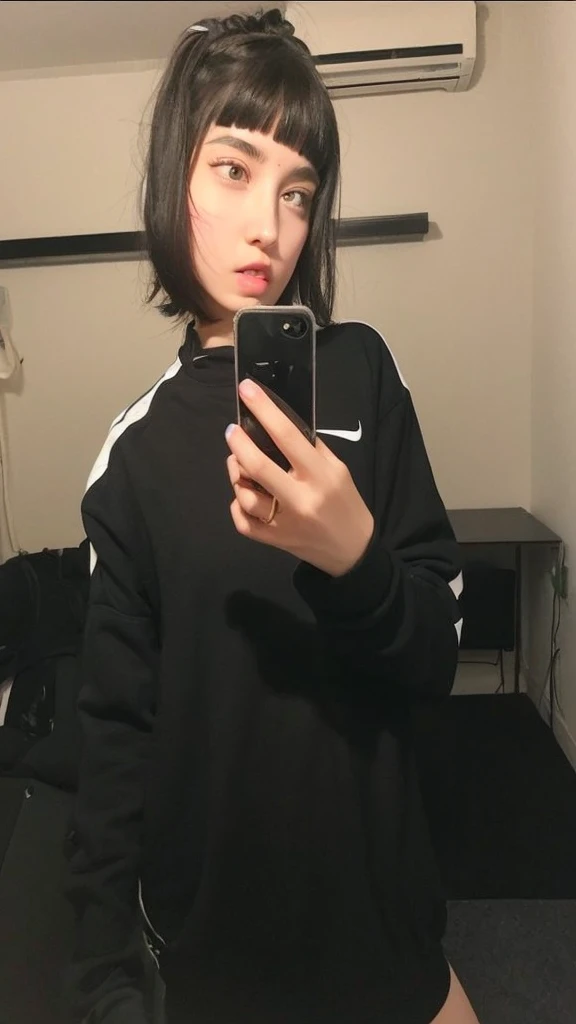 Pale teenage girl with black hair and bangs above her eyebrows, with small pink lips and a potato nose and light green eyes, taking a photo in the mirror with a black and white nike sweatshirt 