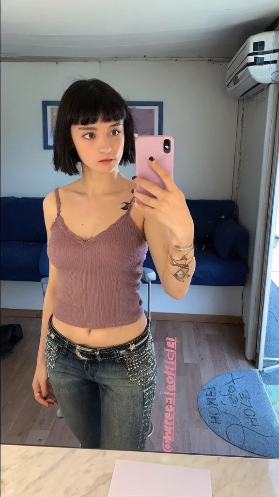 Pale teenage girl with silky black hair and bangs above her eyebrows, with small pink lips and a potato nose and light green eyes, taking a photo in the mirror looking at the cell phone with a light purple t-shirt showing her belly and gray low-rise jeans in good quality