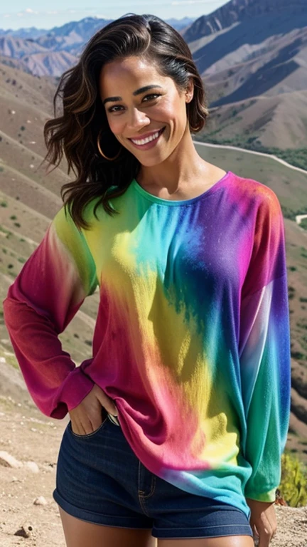 Paula Patton wearing colorful dyed clothes on a mountain and smiling
