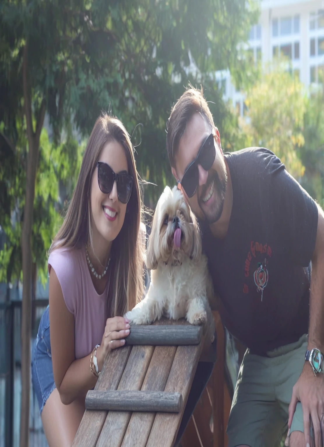 Couple walking their shit tzu dog, giggling, dog with tongue out, mulher loira sorgiggling com oculos de sol. Homem loiro sorgiggling e com oculos de sol. Dog on a wooden slide. Sunny background with trees. (high resolution) (high on details)