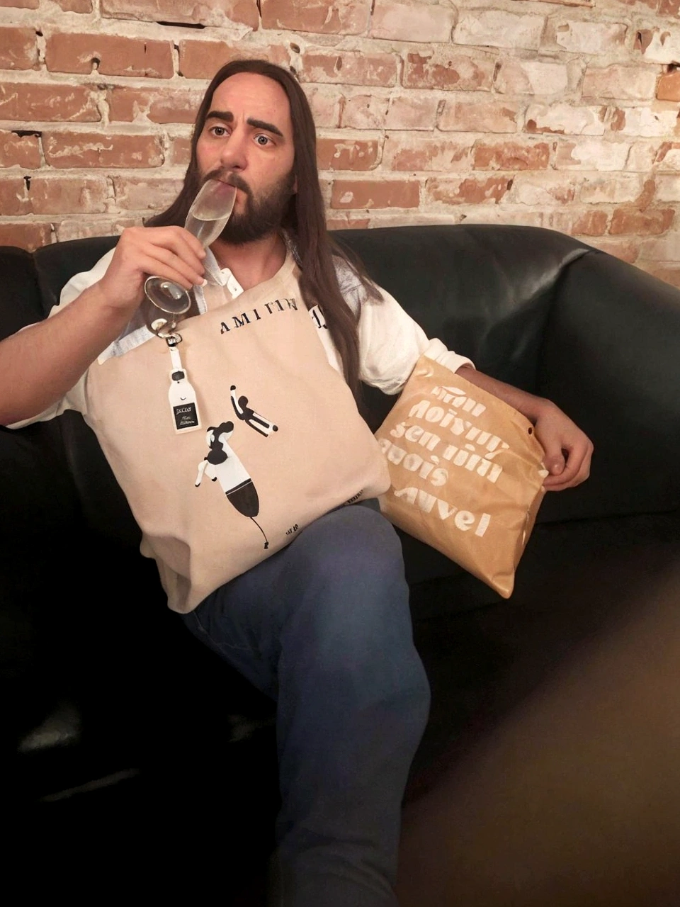 there is a man sitting on a sofa with a bag and a bag of food, sitting not sofa, sitting in a room, sitting not sofa, sitting on a sofa, sentado on a sofa, on a sofa, not sofa sitting, sitting not sofa, spitting pads out of mouth, promo photo, sitting casually, 2020, slightly blurred