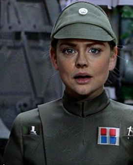 Melissa Joan Hart, in olive green imperial officer uniform and hat, blonde short ponytail, tiny freckles