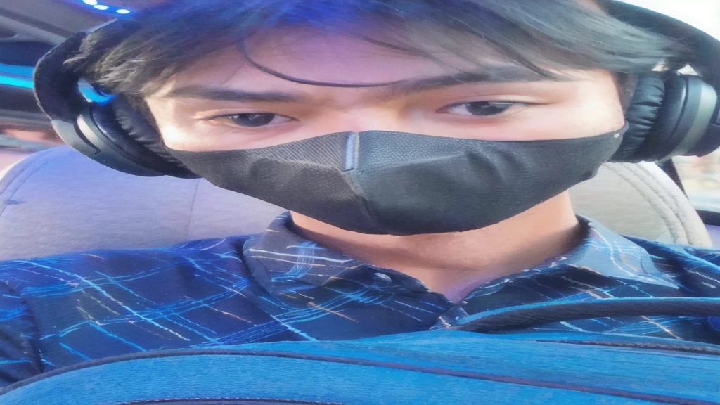 arafed man wearing a mask and headphones in a car, wearing all black mempo mask, wearing facemask, wearing mask, handsome man,