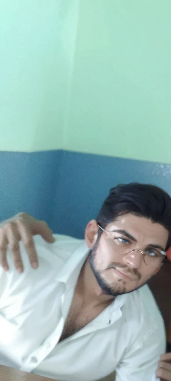 Homme aux cheveux mi-longs attachés avec une barbe de taille moyenne portant des lunettes et une blouse blanche assis à une table fumant une pipe