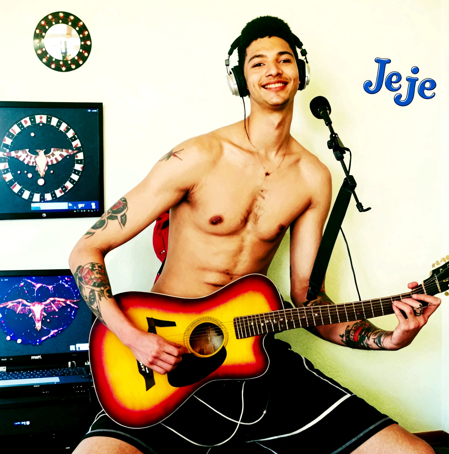 A young man is playing an acoustic guitar in a room that looks unkempt and messy, he wears large Headphones in his ears, has short hair, ((stout body)), and has tattoos on his arms.
