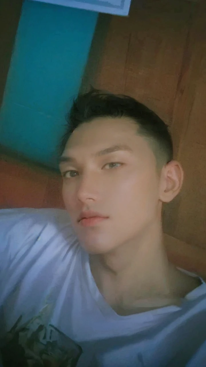 1 boy, handsome, tall and strong, perfect male figure, eyes looking at camera, (tanned skin:1.2), silver hair, serious expression, ray tracing, lying on bed, lay on bed, top view, (best quality,4k,8k,highres,masterpiece:1.2),ultra-detailed,(realistic,photorealistic,photo-realistic:1.37),studio lighting,ultra-fine painting,sharp focus,physically-based rendering,extreme detail description,professional,vivid colors,bokeh,portrait