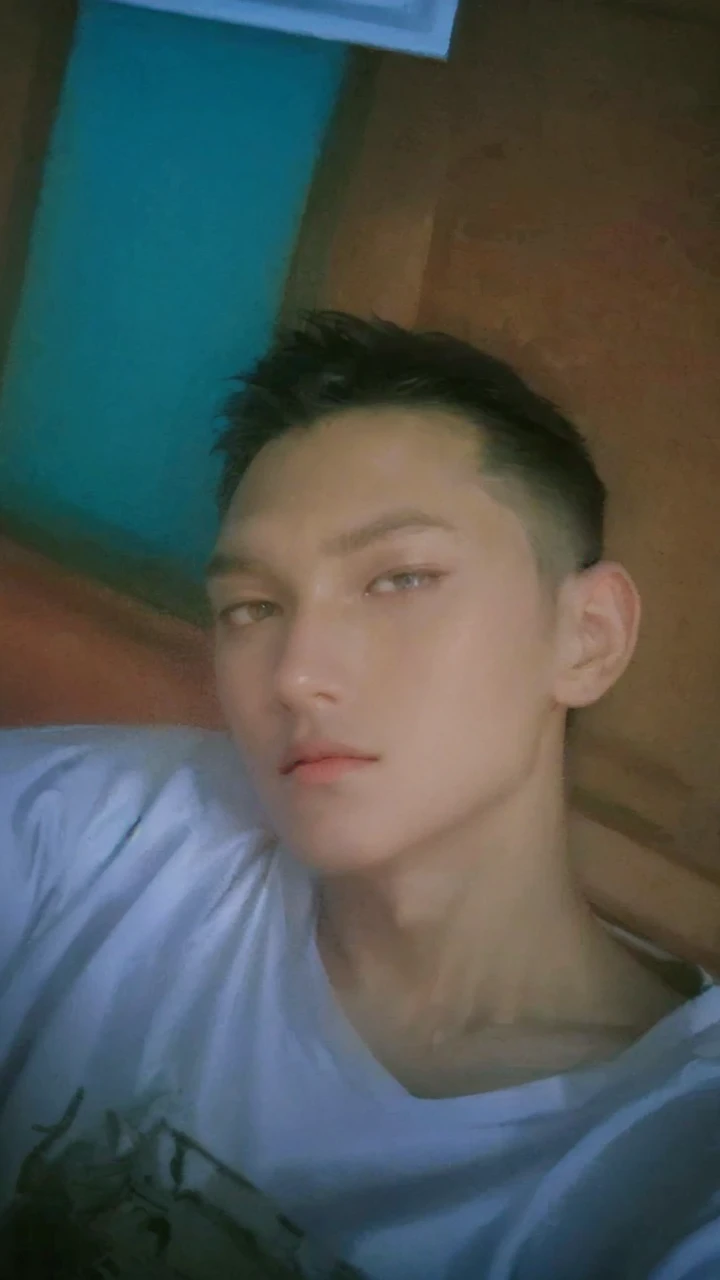 1 boy, handsome, tall and strong, perfect male figure, eyes looking at camera, (tanned skin:1.2), silver hair, serious expression, ray tracing, lying on bed, lay on bed, top view, (best quality,4k,8k,highres,masterpiece:1.2),ultra-detailed,(realistic,photorealistic,photo-realistic:1.37),studio lighting,ultra-fine painting,sharp focus,physically-based rendering,extreme detail description,professional,vivid colors,bokeh,portrait