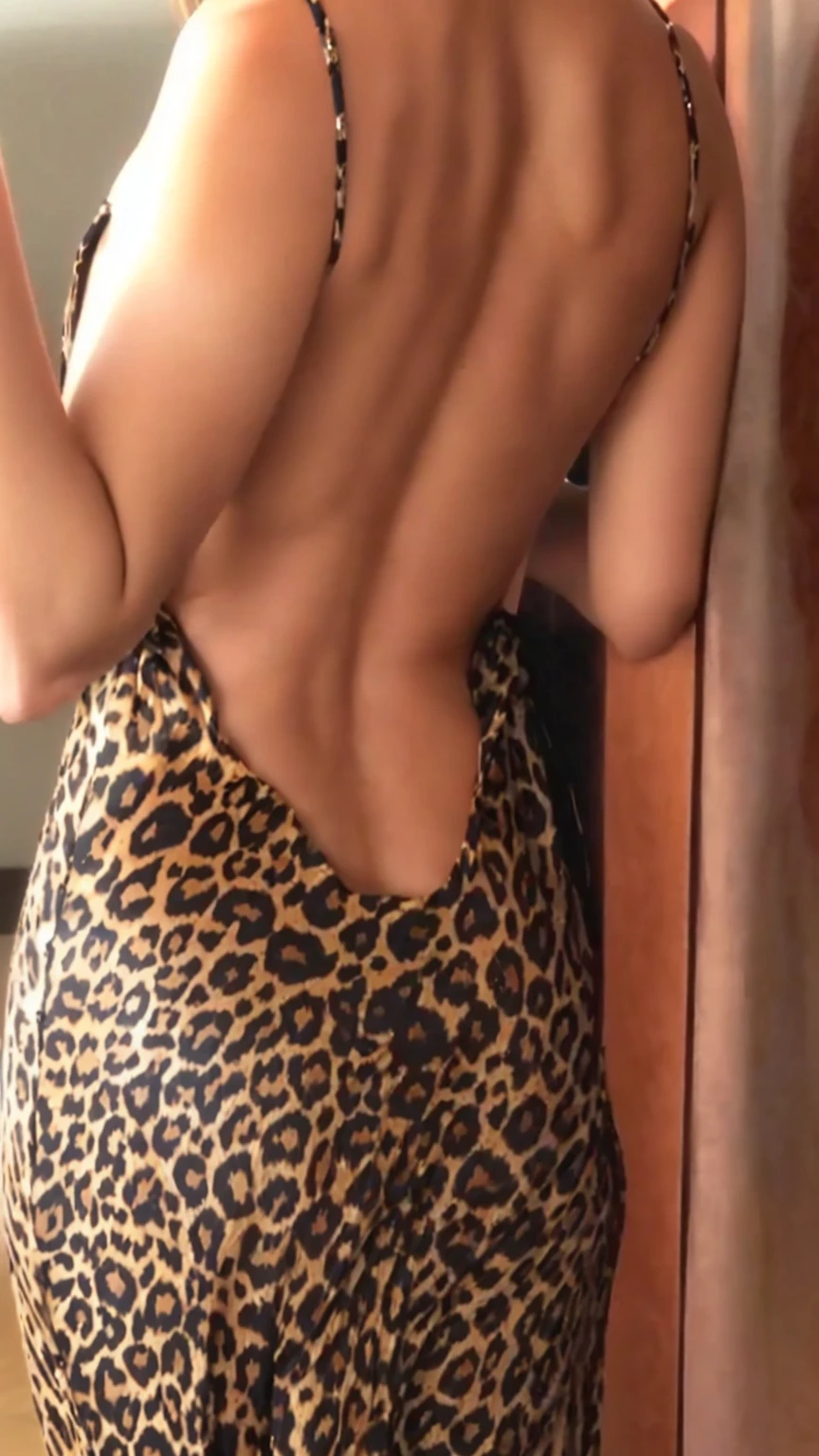 a close-up of a woman in a leopard print dress, back slit, rear view, dress open nas costas, photo taken from behind, back - shot, bare back, rear view, exposed back, rear view também, visto from behind, photo from behind, dress open, from behind, showing her shoulder from behind, complete view, 30 year old woman