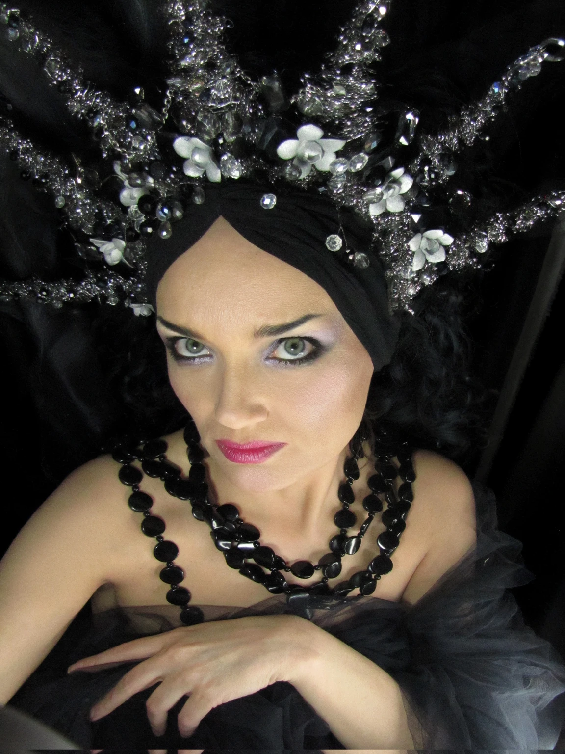 dslr hdr proffesional photo, arafed woman, long curly ultradetailed hair , black hair, textured hair, wearing a black dress and a tiable with pearls and beads, inspired by Ursula Wood