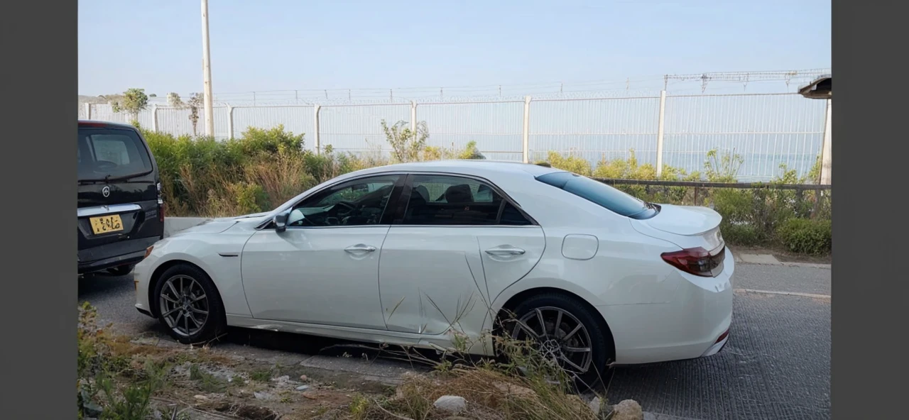Change the background of the white private car to a beautiful sunset