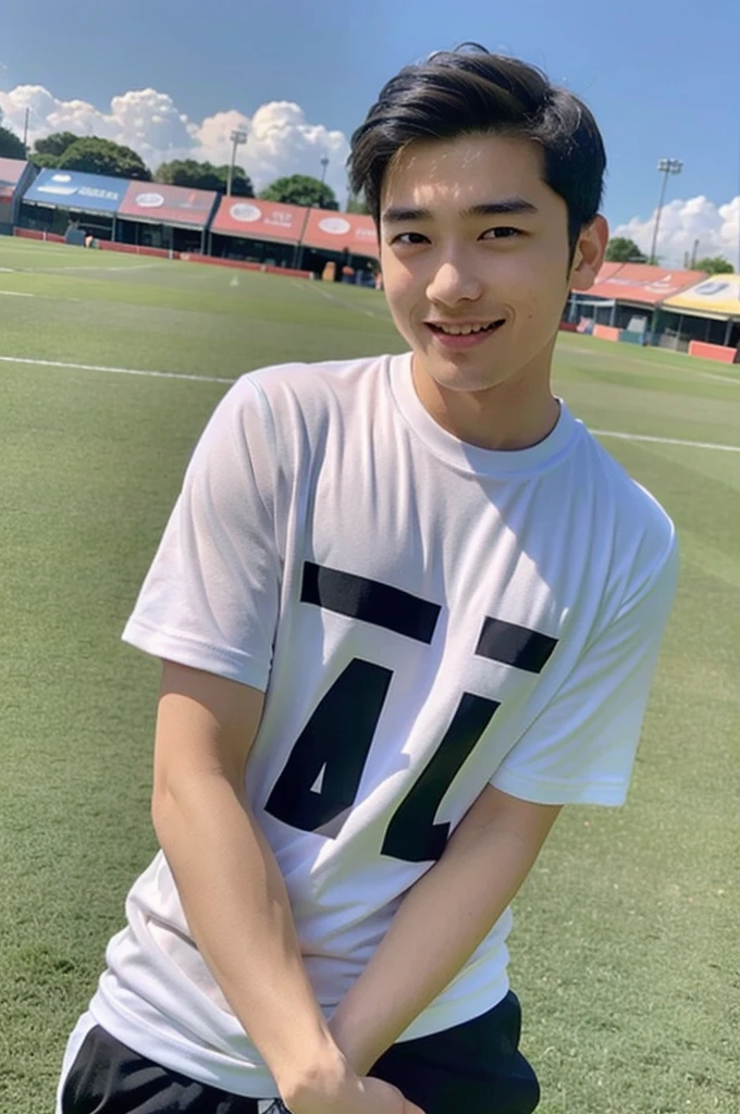young asian man Looking at the camera in a sports shirt , Fieldside, beach, sunlight, looking at the football field