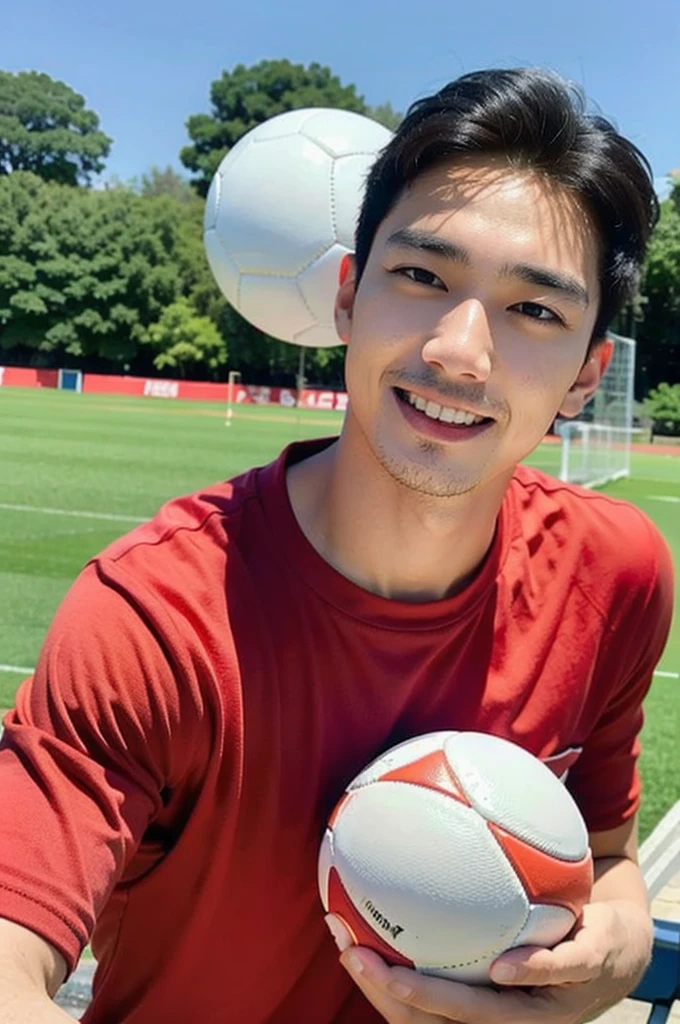 young asian man looking at camera in a red sports shirt , Fieldside, beach, sunlight, looking at the football field