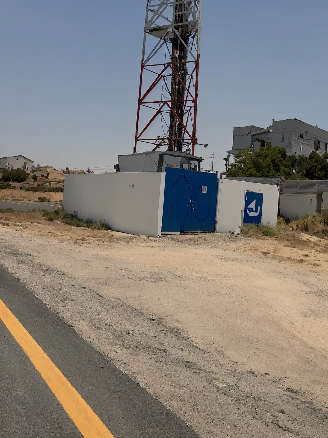 there is a cell tower on the side of the road, ( land ), photo from 2022, by Daarken, by Dr. Atl, very very low quality picture, unusual composition, building in the distance, photograph taken in 2 0 2 0, taken on iphone 1 3 pro, detailed wide shot, mid-view, interesting composition, large view