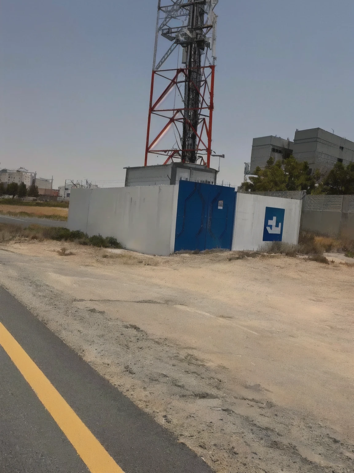 there is a cell tower on the side of the road, ( land ), photo from 2022, by Daarken, by Dr. Atl, very very low quality picture, unusual composition, building in the distance, photograph taken in 2 0 2 0, taken on iphone 1 3 pro, detailed wide shot, mid-view, interesting composition, large view