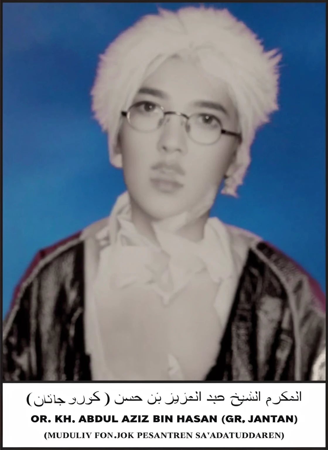 a man dressed in white and black, wearing a white imamah, wearing glasses