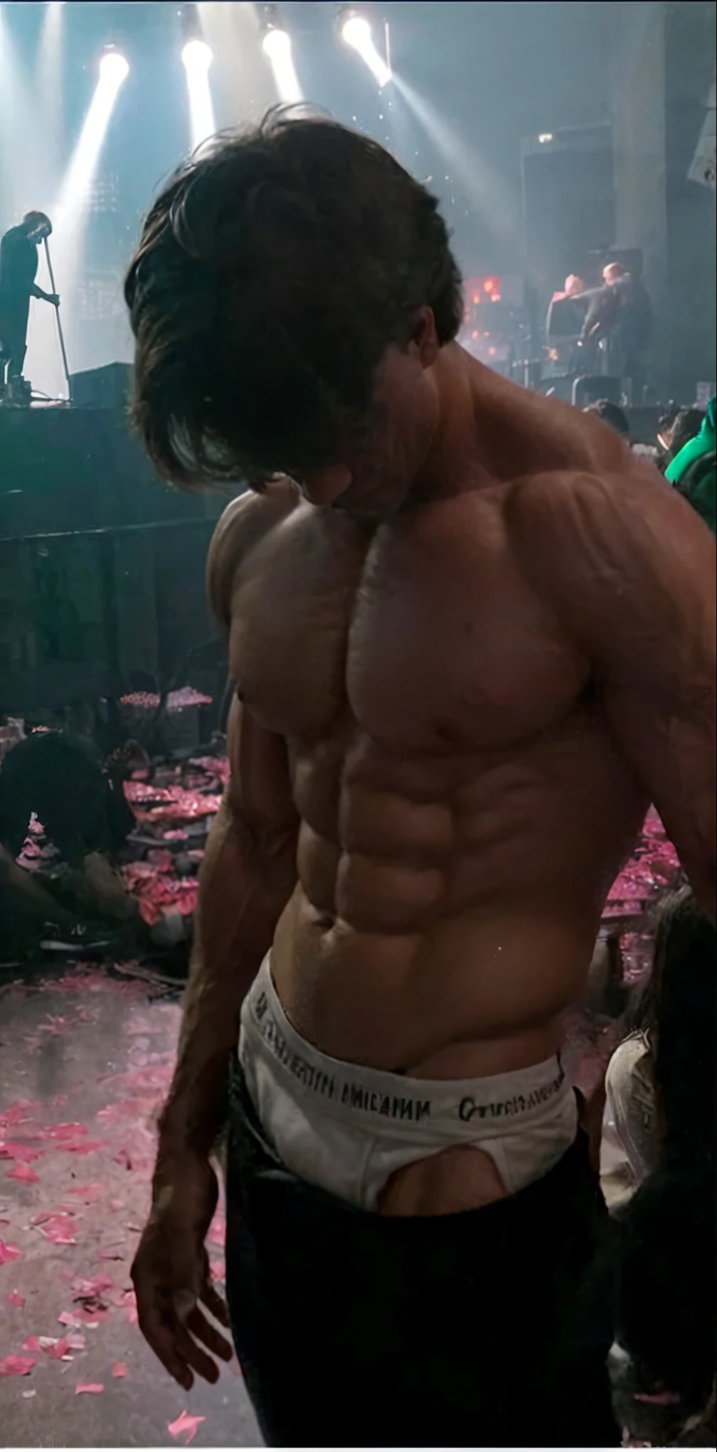 A huge muscular very young alpha male bodybuilder, extremely large and defined muscles, handsome attractive face, ripped abs, veiny arms, broad shoulders, whole body and each muscle flexed, posing shirtless, head looking down, at a concert, studio lighting, (best quality,4k,8k,highres,masterpiece:1.2),ultra-detailed,(realistic,photorealistic,photo-realistic:1.37),award-winning,highly detailed,intricate,cinematic, dramatic atmosphere,chiaroscuro lighting,striking pose,muscular physique,powerful,intimidating,commanding presence