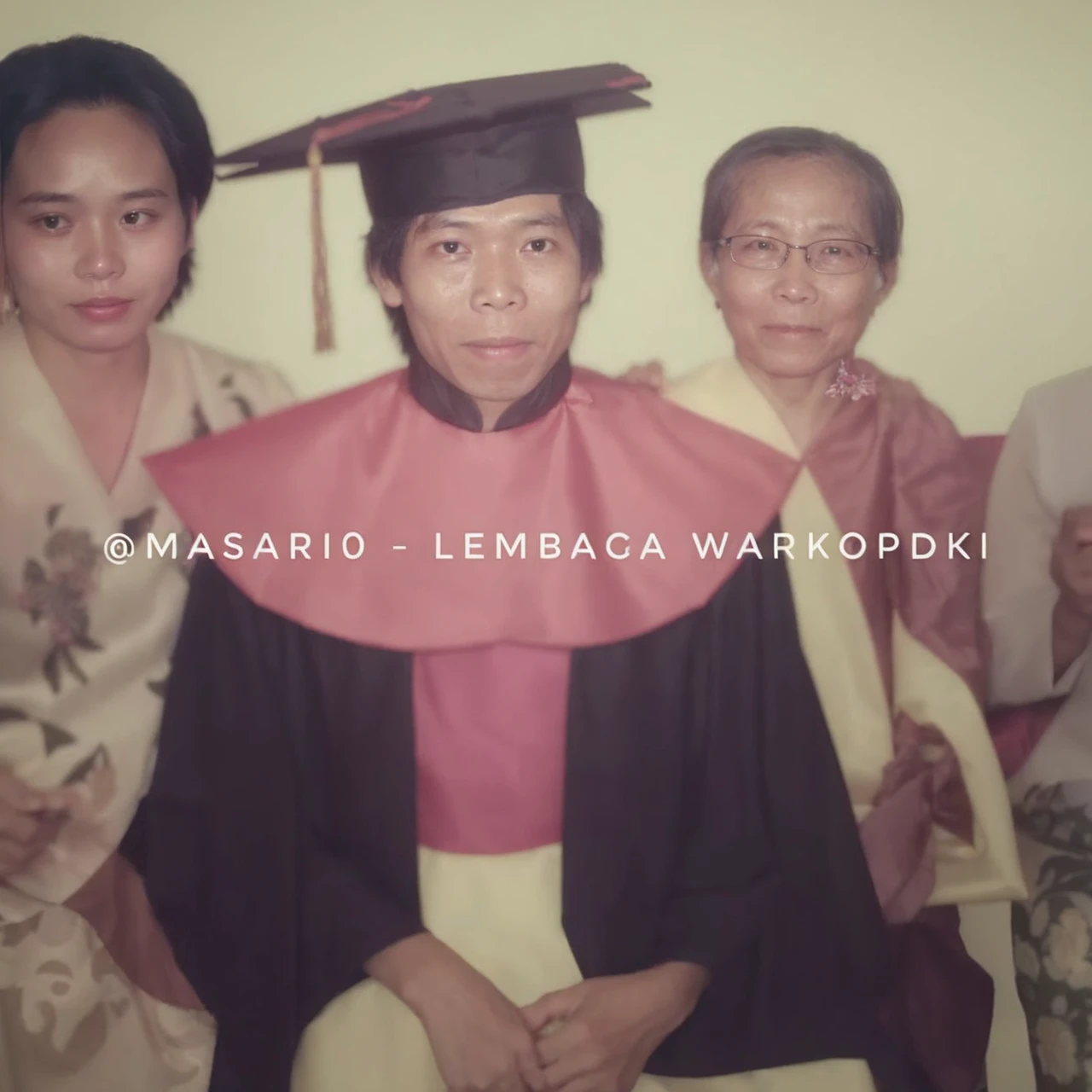  The image captures a touching moment from a family celebrating graduation. The graduate sat between his mother and older sister, the mother and brother wore traditional Indonesian batik clothes. proudly posing for a photo, with graduates at the center of their excitement.