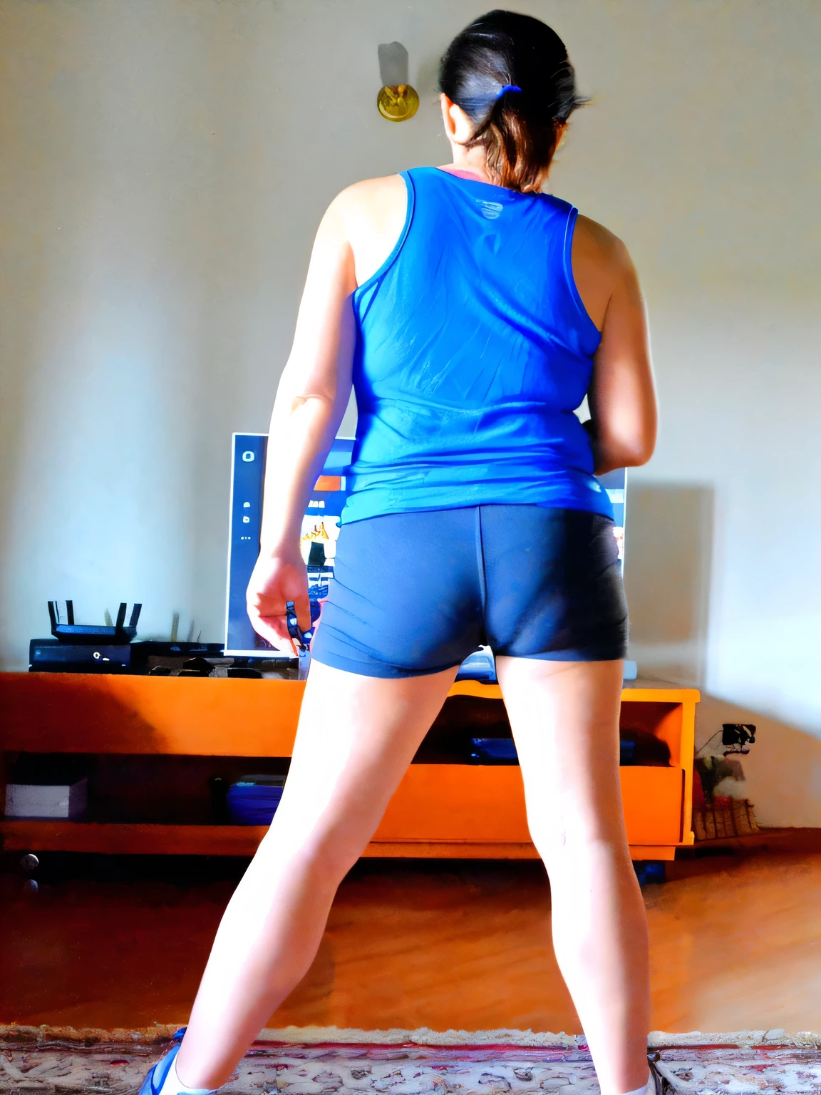 there is a woman in a blue shirt and black shorts playing a video game, long shot from back, long shot from the back, rear-shot, back - shot, shot from the back, back shot, backshot, from back, back pose, backview, in shorts, from the back, back view!!, sport bra and dark blue shorts