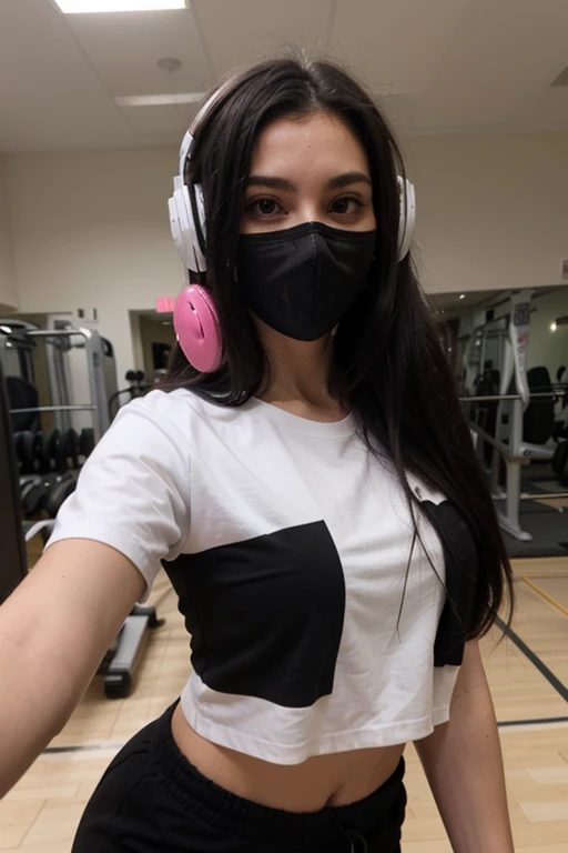 Sexy girl with long black hair wearing white long shirt and black joggers taking a selfie, with a black mask with pink headphones in the gym