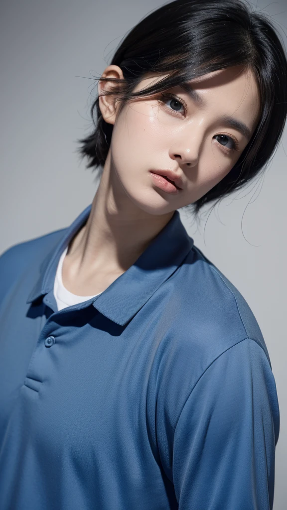 a black-haired, black-eyed, white-skinned man wearing a blue shirt