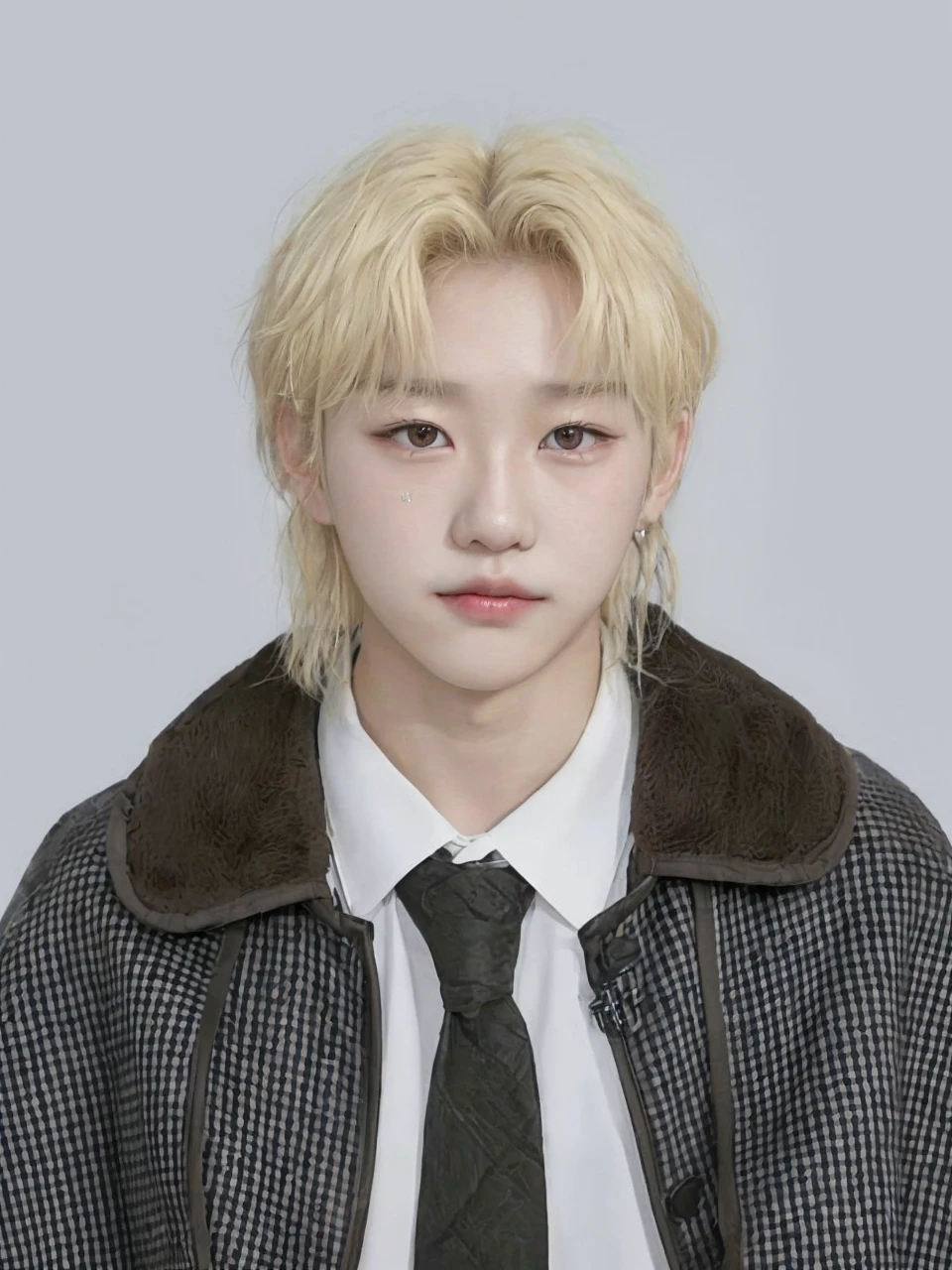 Korean boy. Characteristics: blonde hair + locks falling on the forehead + brown eyes. (Félix from the band SKZ - Stray Kids)